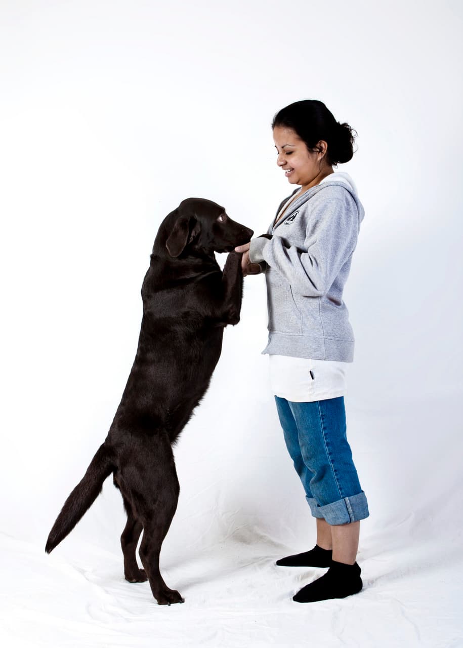 En sort labrador rejser sig op ad Nanna med forpoterne